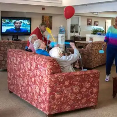 Residents sitting on couch playing with a red balloon
